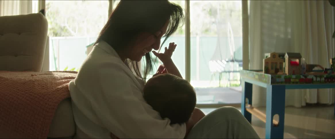 Mother sitting in the living room playing with her baby on her lap
