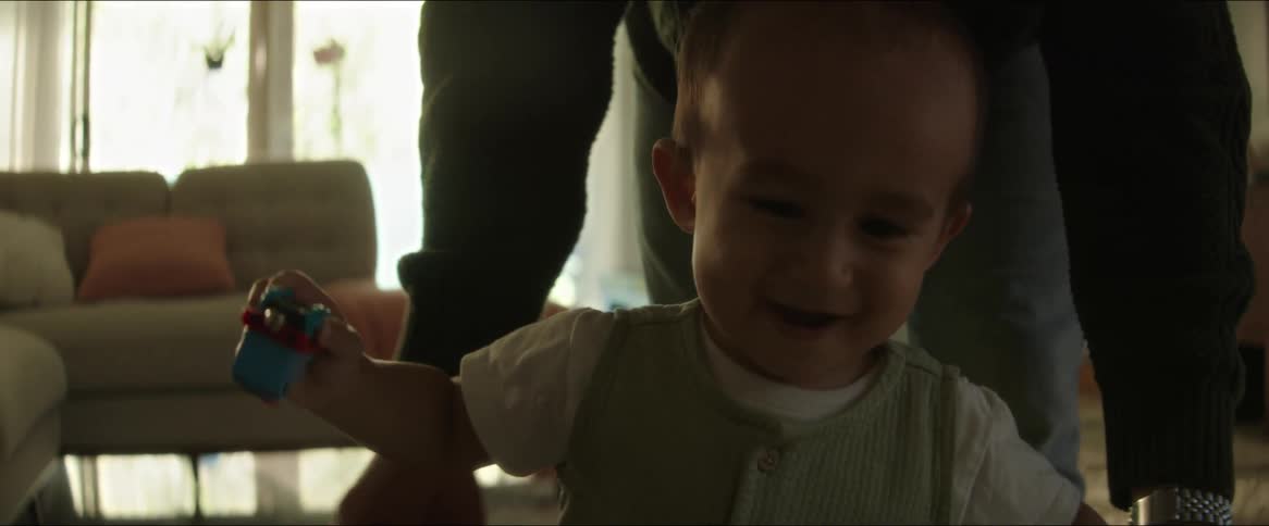 Small child learning to walk with the help of his father