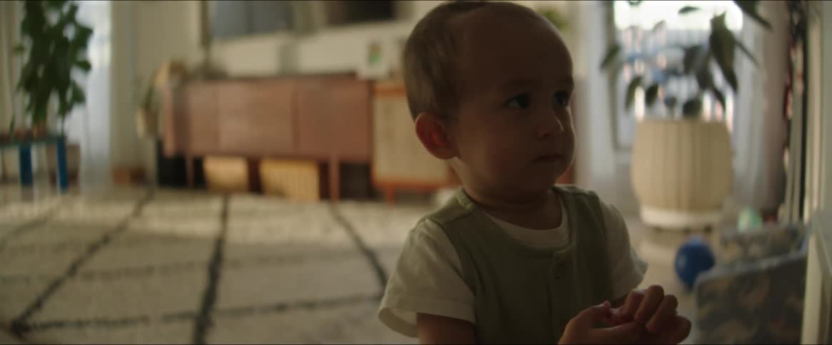 Small child clenching hands in living room