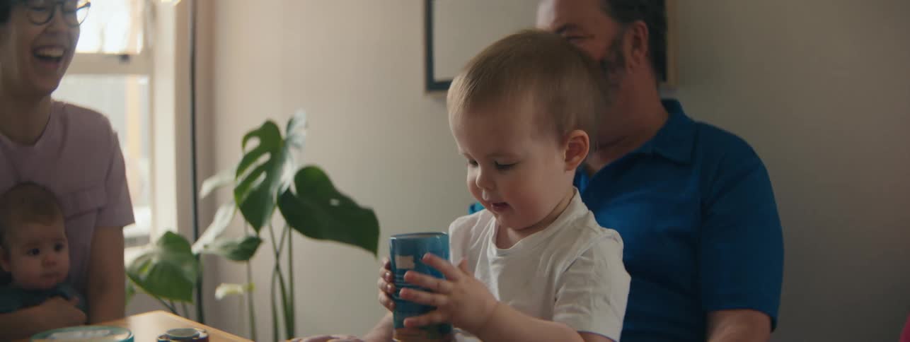 Parents watch as a baby plays with toys