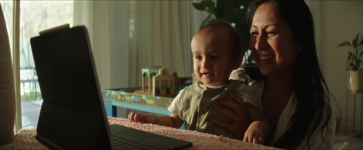 A clip of a mother and son playing beside the tablet