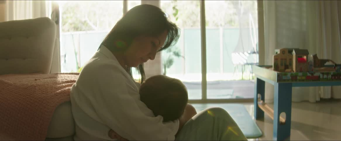 Mother sitting on the carpet with her baby on her lap