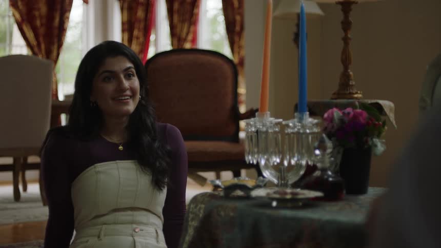 Woman sitting at an elaborately decorated table smiles while talking to another person