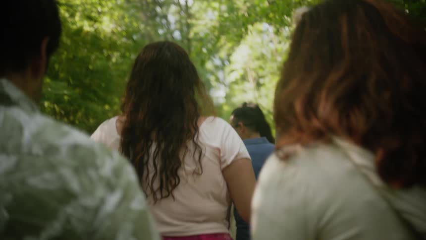 Group of young friends walking along a trail in a forest