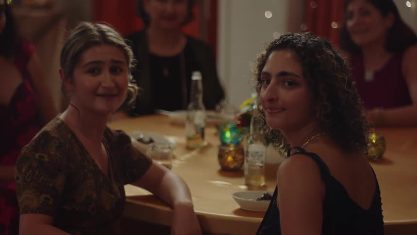 Group of women sitting at a table looking with happy facial expression in the same direction