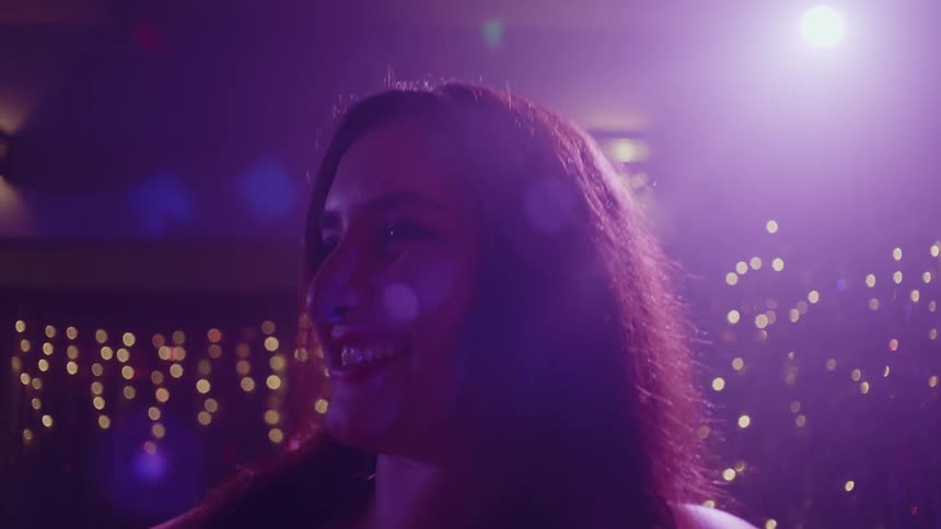 Woman in a party hall with happy facial expression dancing