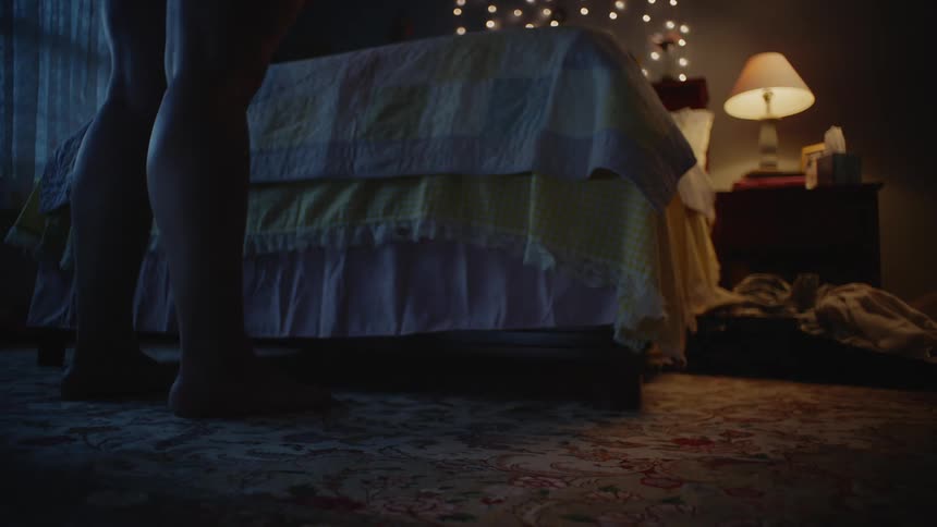 A person is standing in their bedroom at night