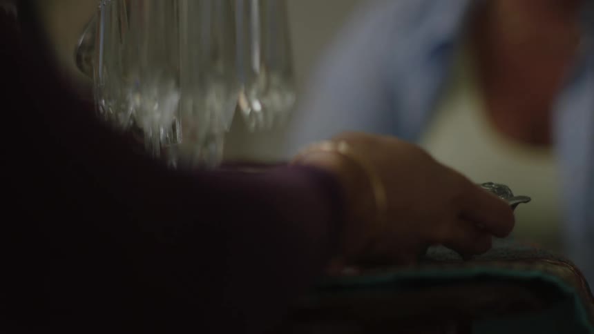 Persons hand placing a small metal bowl on the table