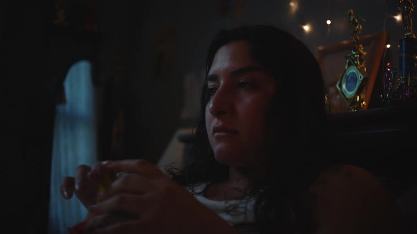 Woman lying in bed eating snacks