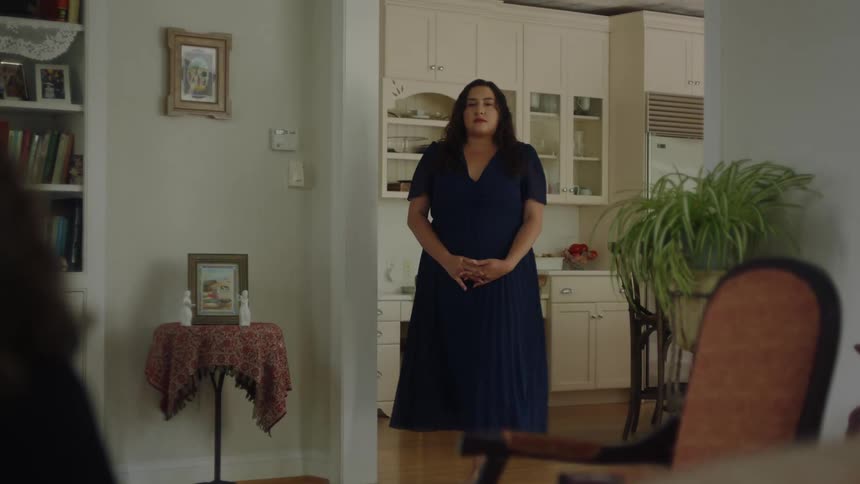 Woman in long blue dress walking towards living room