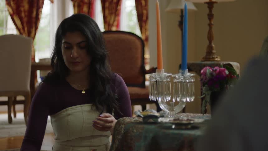 A young woman placing a glass bowl on a table with some similar items