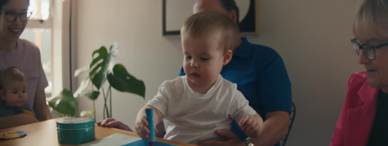 Family with young children sitting at table and interacting