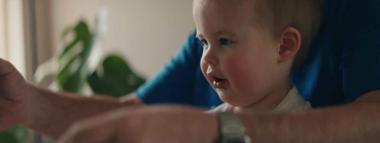 Portrait of a small child sitting on an adult and playing