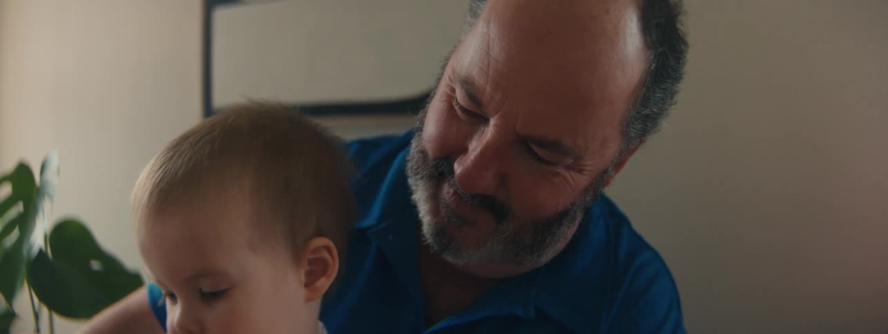 Grandfather sitting with his little grandson playing