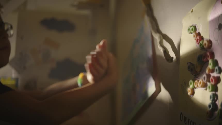 A child makes a shadow puppet of a bird