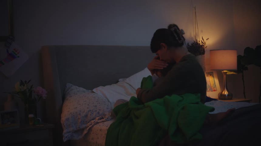 Mother sitting on the bed with her little son on her lap