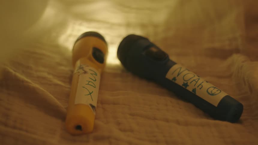 Two lanterns with names on them above the bed
