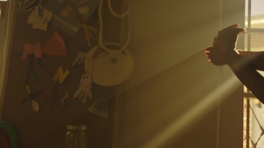 Person makes a flapping bird shaped shadow hand puppet in a shadowy room during the day