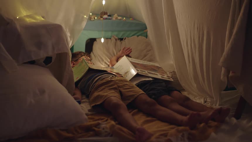 Two children lying on sheets on the floor of a room sleeping