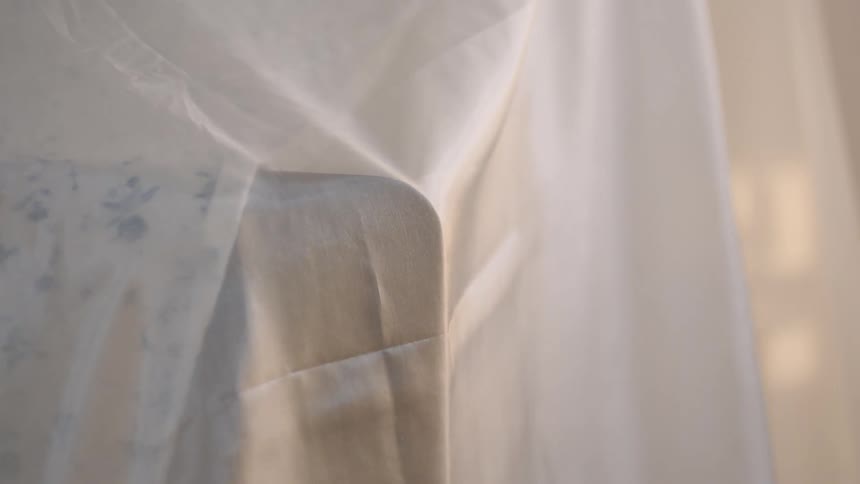 Boy grabs a curtain being pulled over a chair