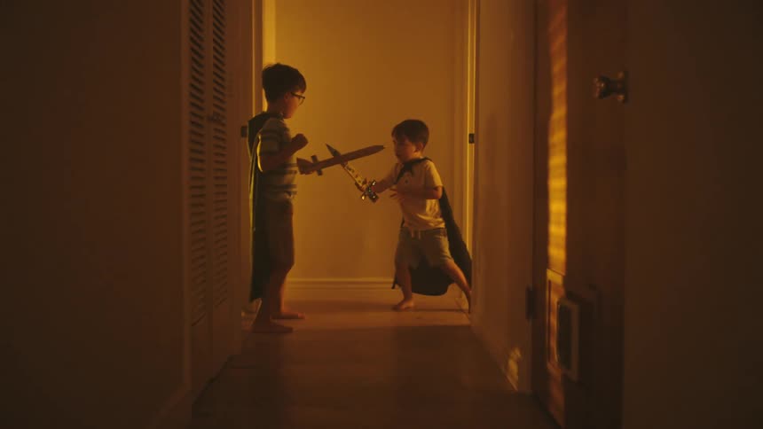 Two kids playing with wooden swords