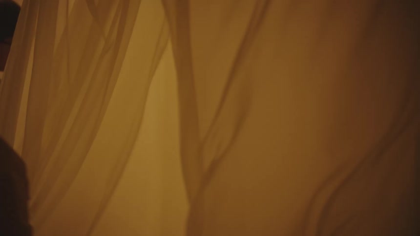 Two boys running around having curtains holding flashlights and playing