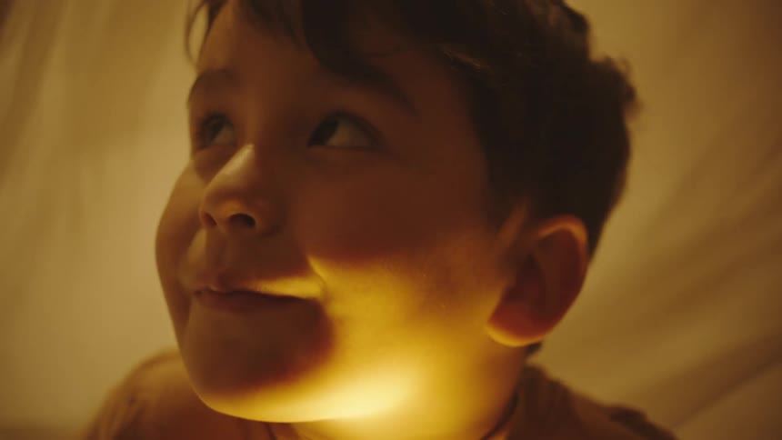 Portrait of a little boy looking sideways with a sheet in the background