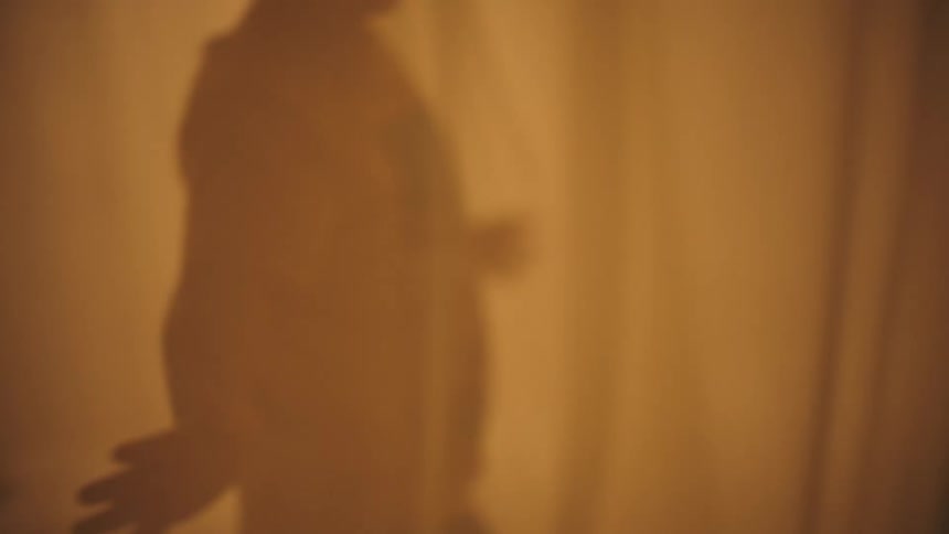 Two boys running between curtains