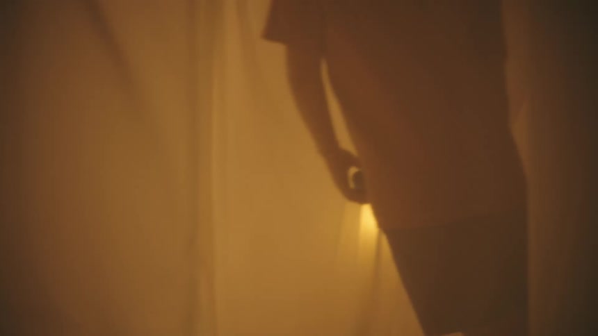 Behind sheer curtains a child collapses and falls