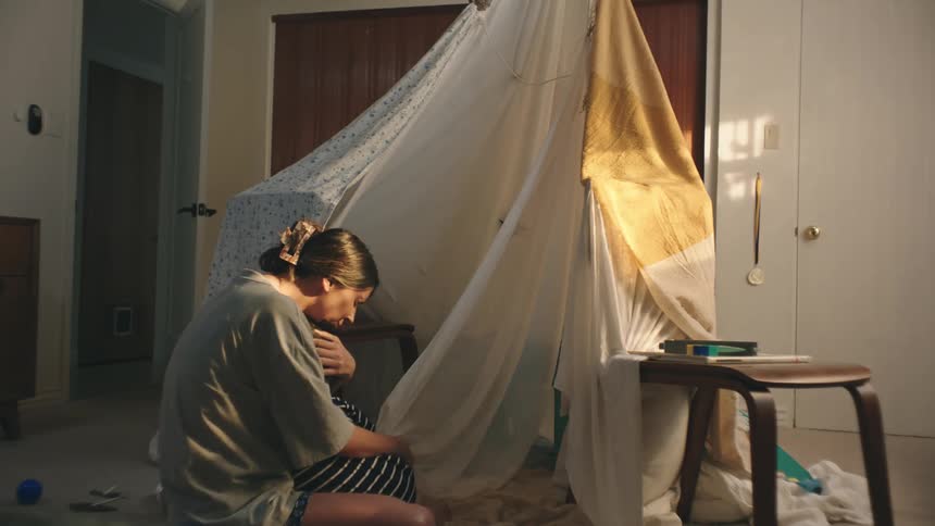 Mother entering the room and hugging her son