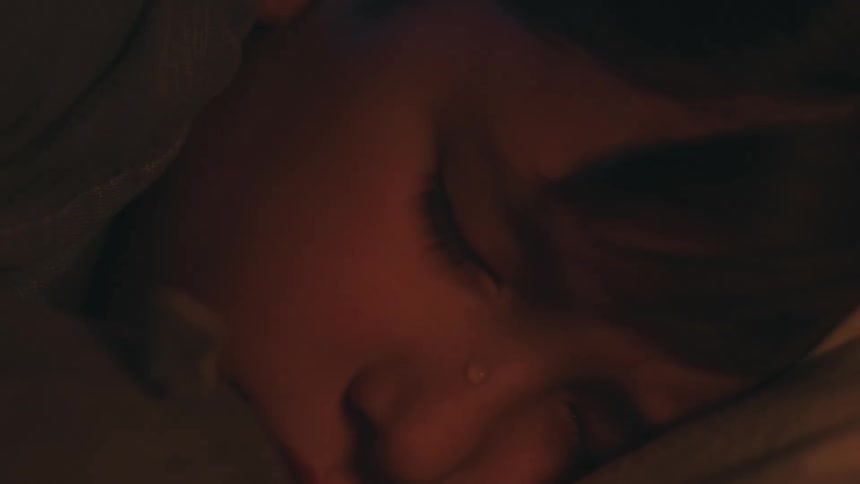A young boy cries as he turns his head into a blanket