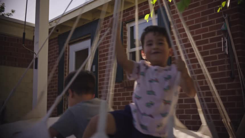 Boys play on a wing in the house yard on a summer day