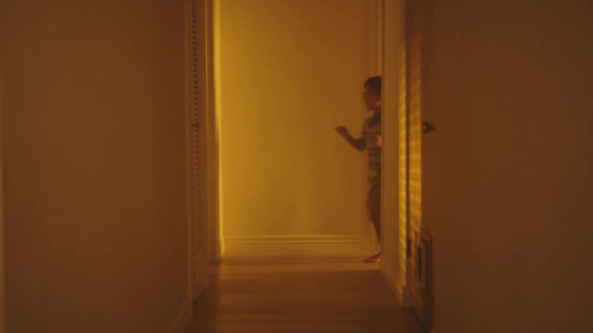 Two boys running down the hallway of the house playing