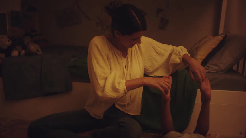 A lady playing with a boy in the room