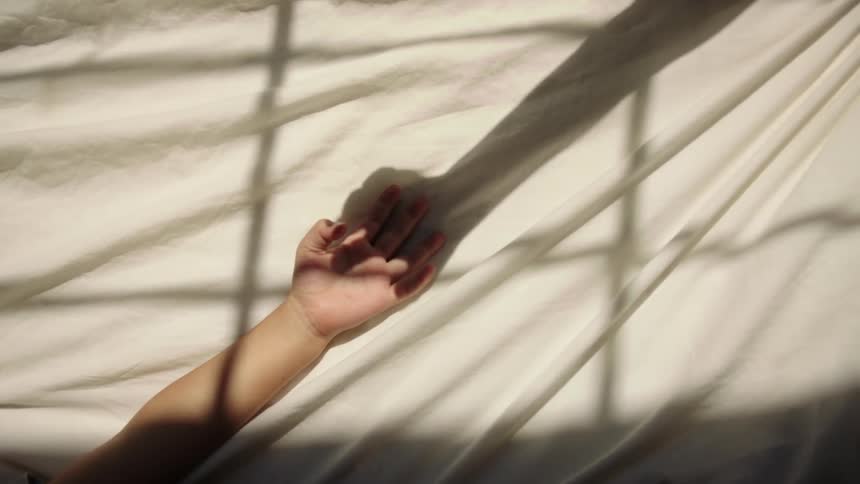 Childs hand interacting with the shadow of another hand