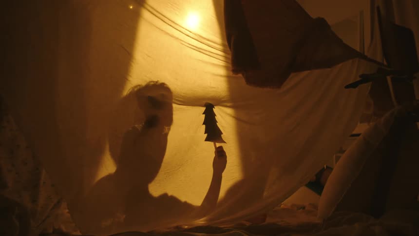 Two children in a room with their shadow against a sheet