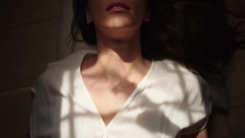 Woman lying on the floor with sunlight reflection