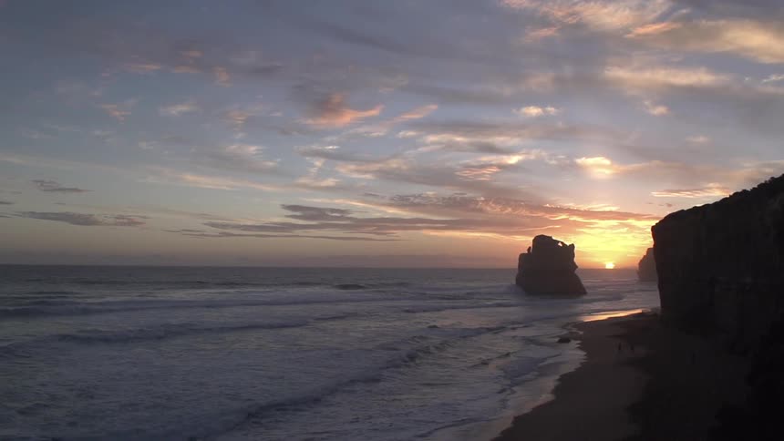 View of a coast with waves crashing on the beach at sunrise