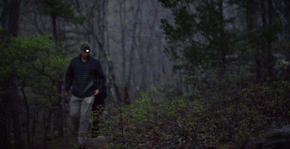 Couple hiking the wilderness with the help of their headlamps