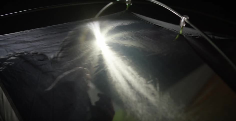 A man setting up a tent at night