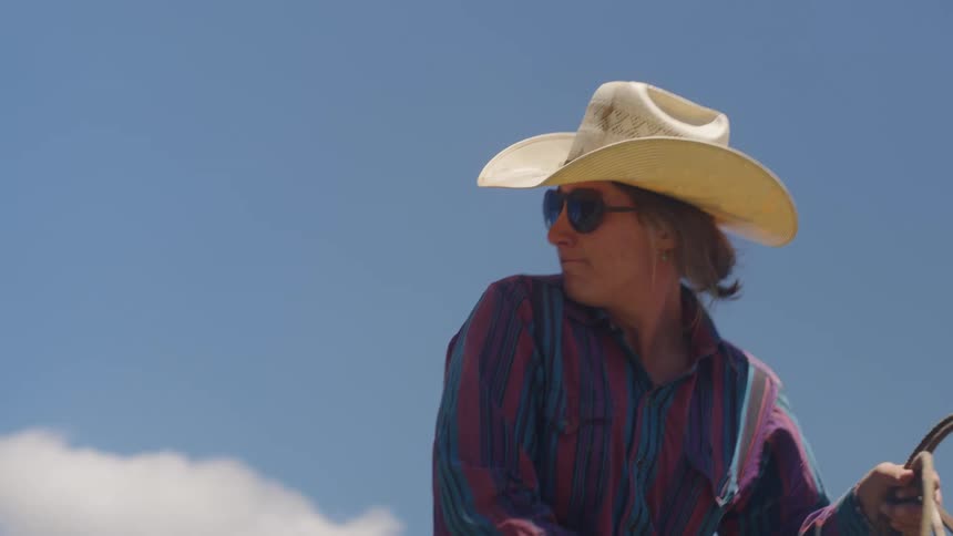 Woman on horseback with sunglasses and hat