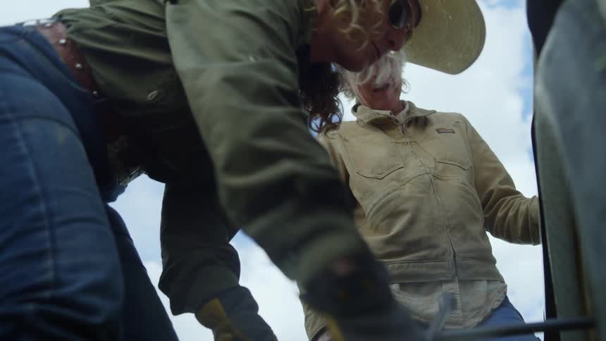 A woman is changing a tire with a tire iron