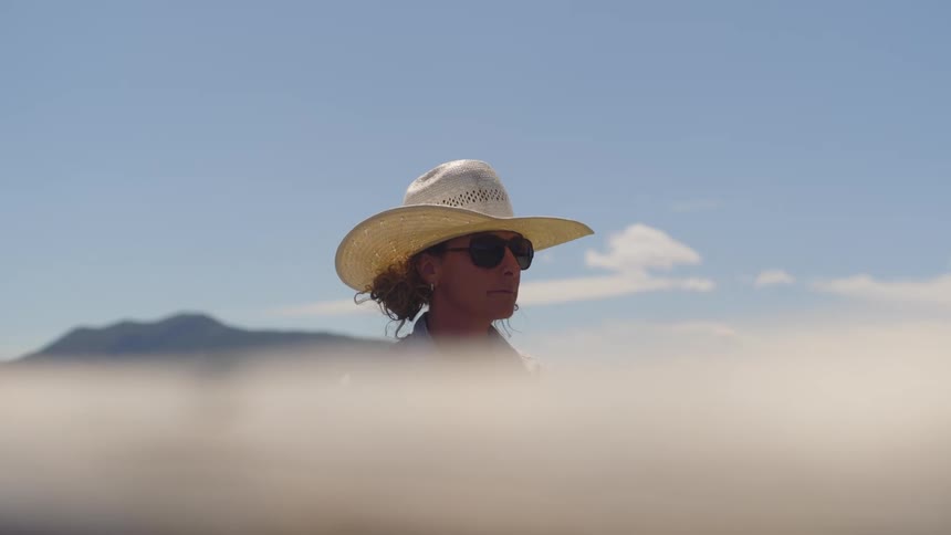 Woman in hat and sunglasses in an outdoor setting
