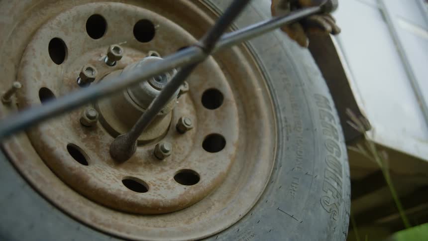 Person changes the tire on a trailer