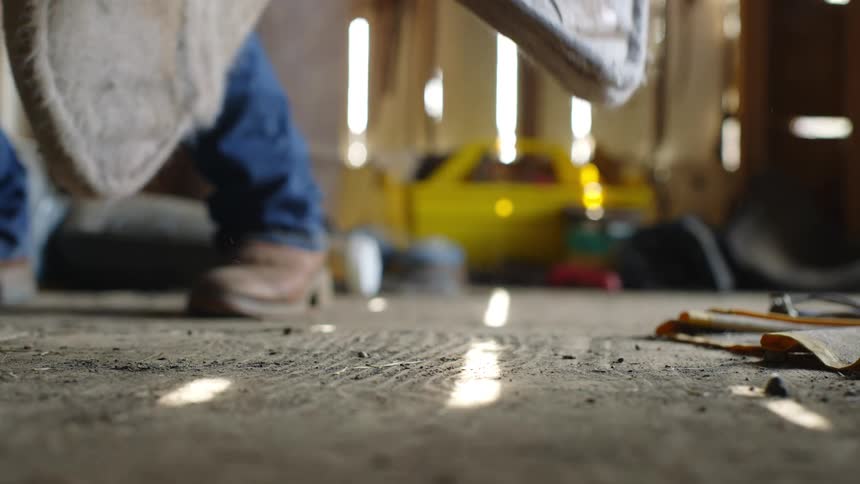 Legs of a person walking inside a wooden shed