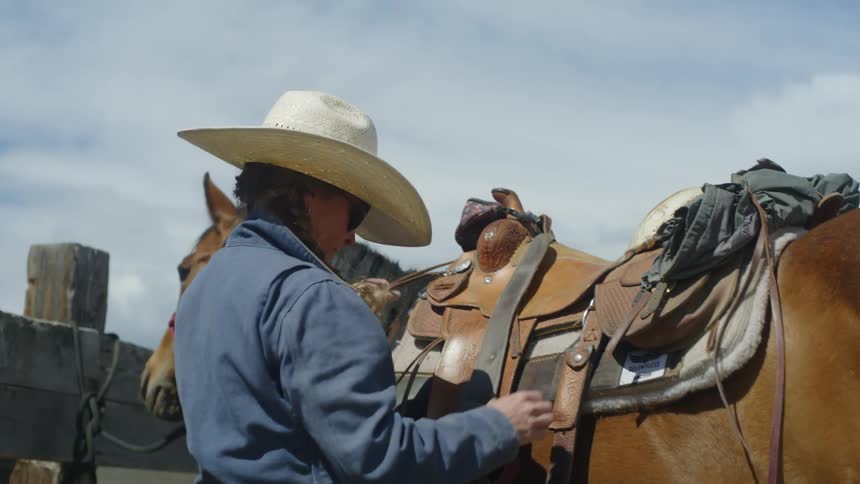 A clip of horse riders preparing the horses