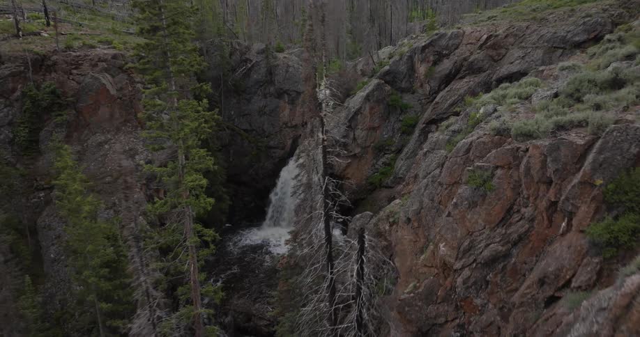 Aerial view of a waterfall falling freely between the cliffs of a ravine