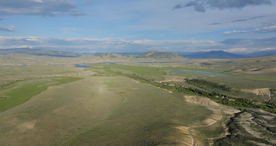 Aerial view of a field with a road and a lake