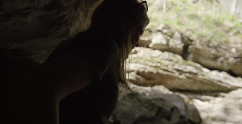 A woman climbs out from under the rocks