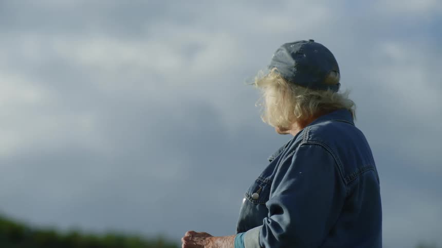 Woman wearing a cap in an openair environment on a cloudy day